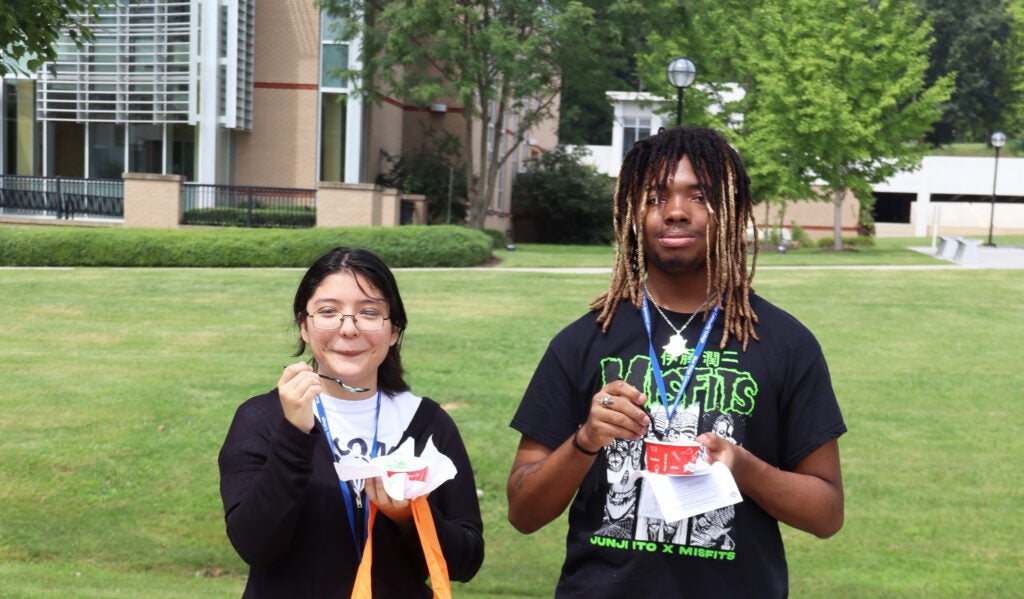Two students enjoying cups of ice cream on the quad