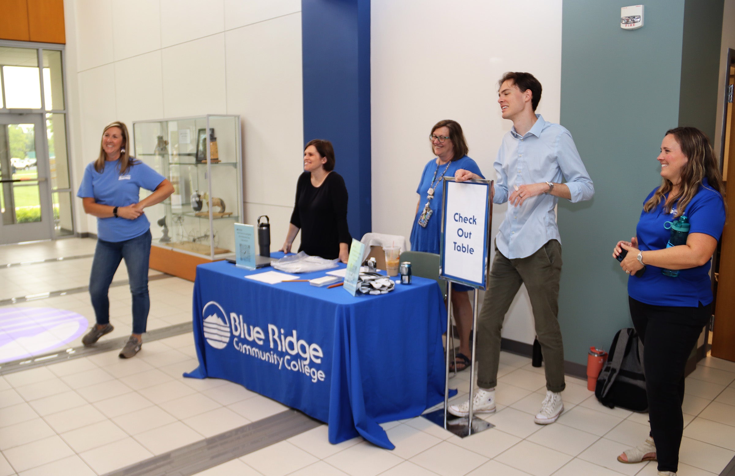 Staff around a blue table welcoming students to Houff Student Center