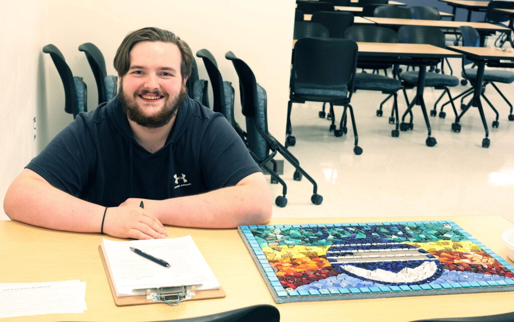 One male student working on the mosaic