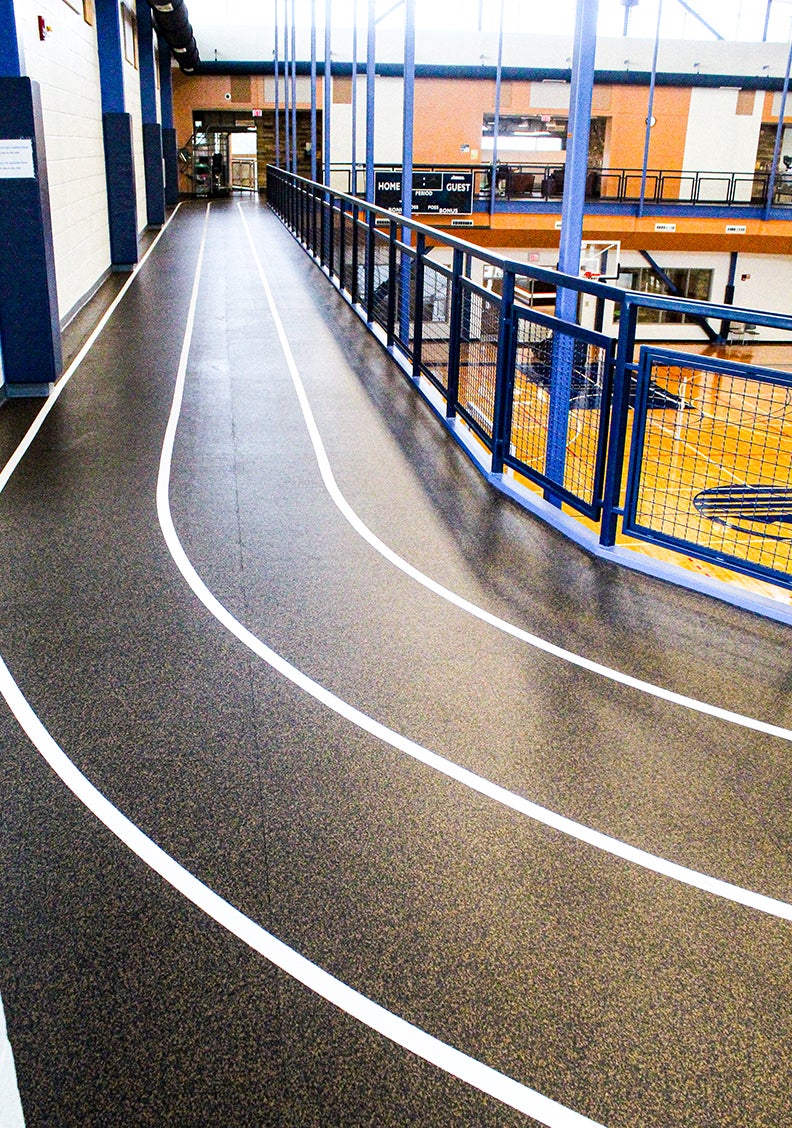 Walking track in the rec center, around the gym on the second floor, showing black smooth empty track marked with white lines