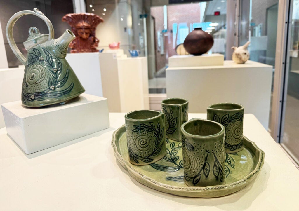 Teapot and cups with a green swirls and vegetation motif