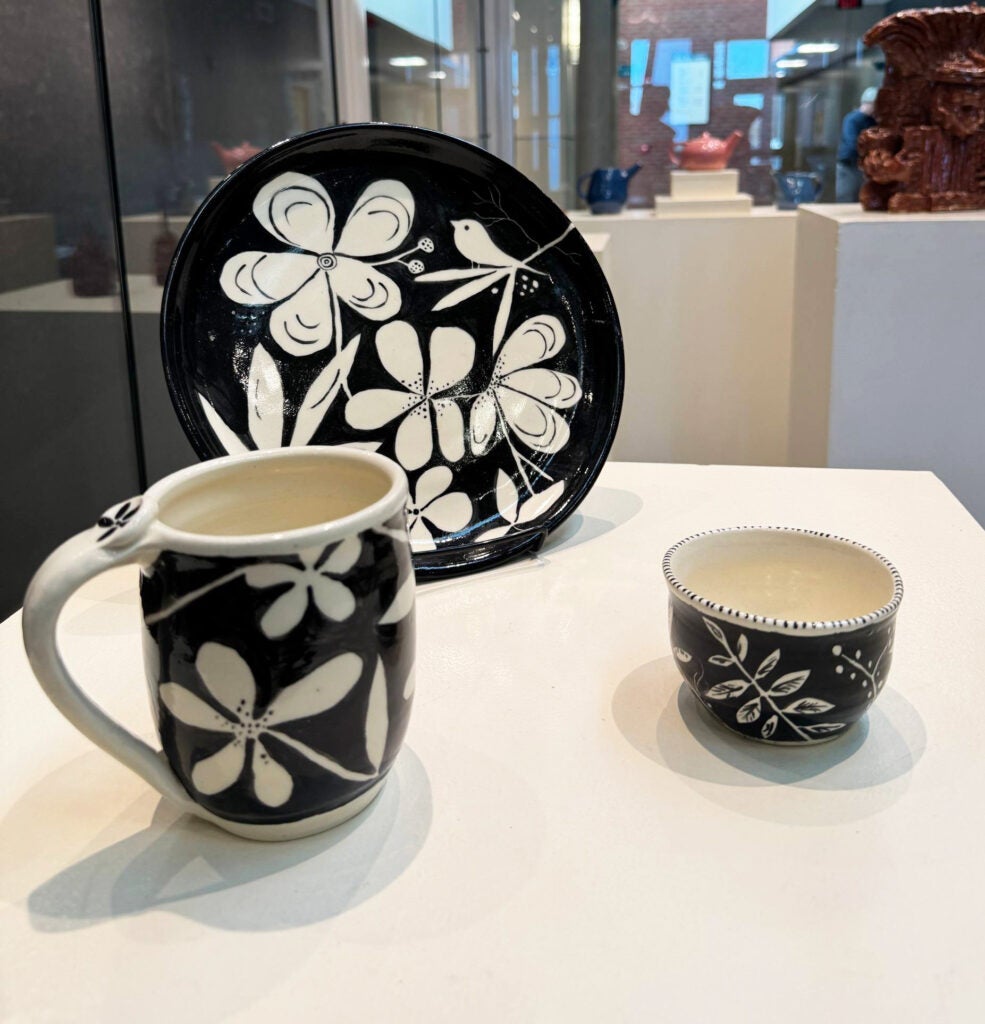 black and white cup, mug, and plate with floral motif