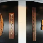 Zeke Trainum exhibition featuring stones set into smooth pieces of wood on black panels